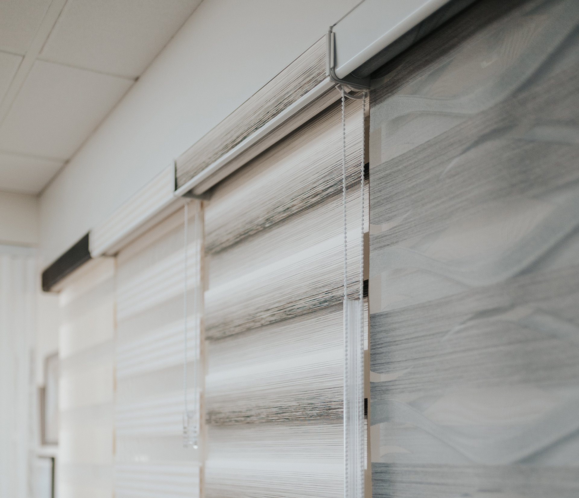 Custom blinds installation by Novo Blinds in an Edmonton home — living room with warm natural light through roller shades
