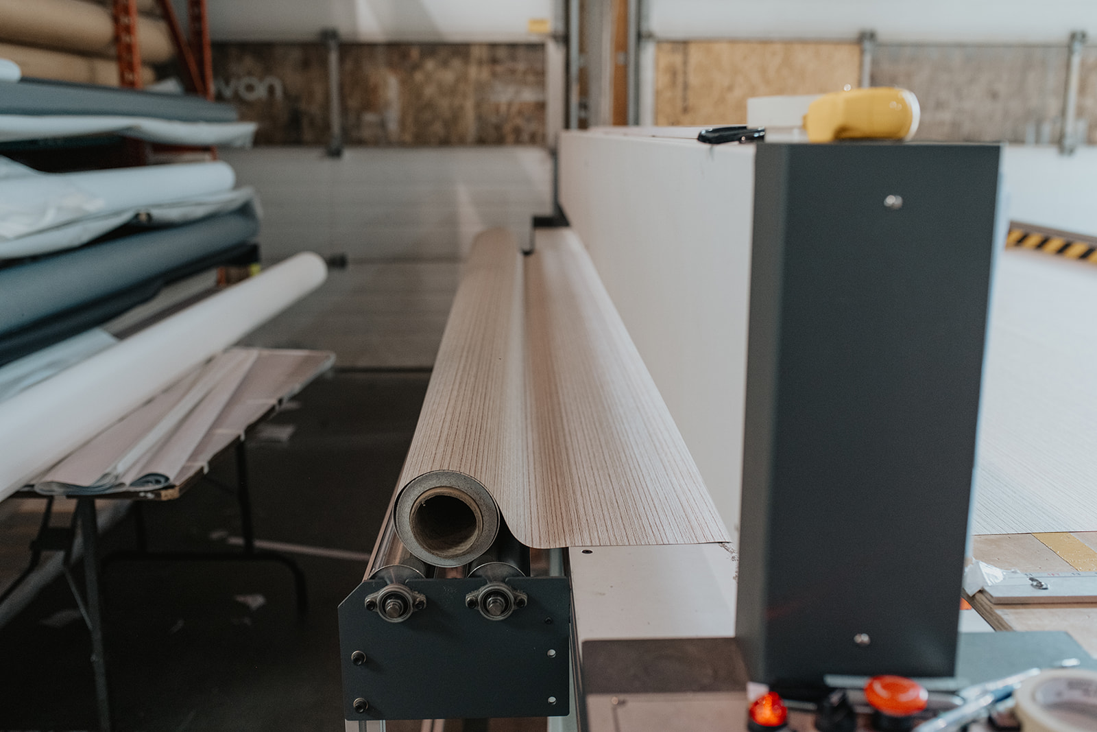 Inside the Novo Blinds Edmonton factory — custom roller shade fabric on the cutting line