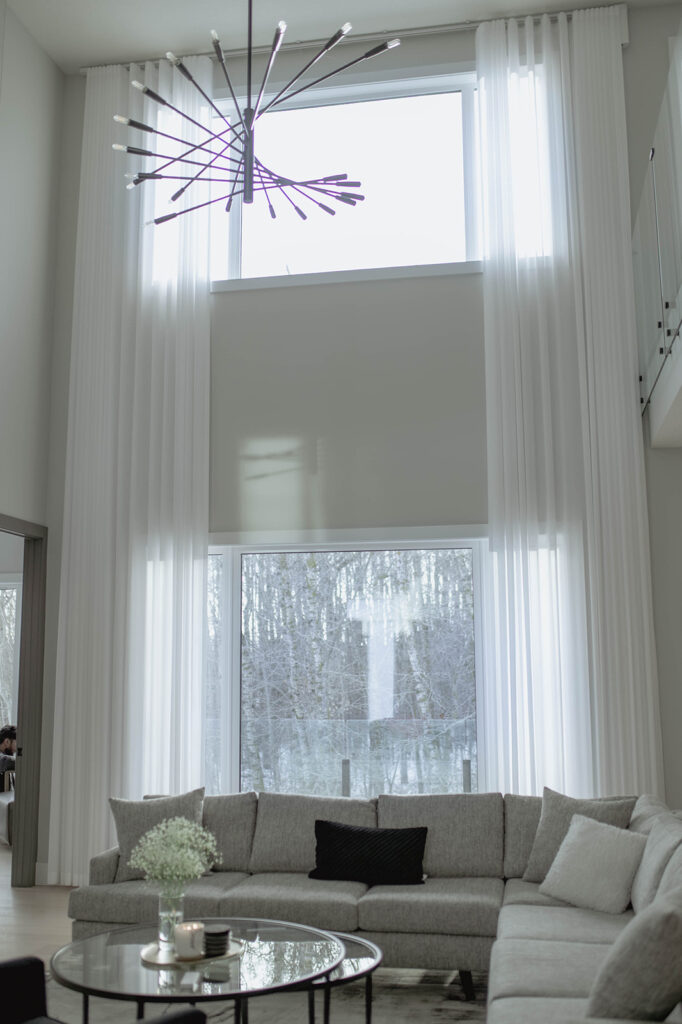 Modern bedroom with custom roller shades by Novo Blinds in a Windermere Edmonton home