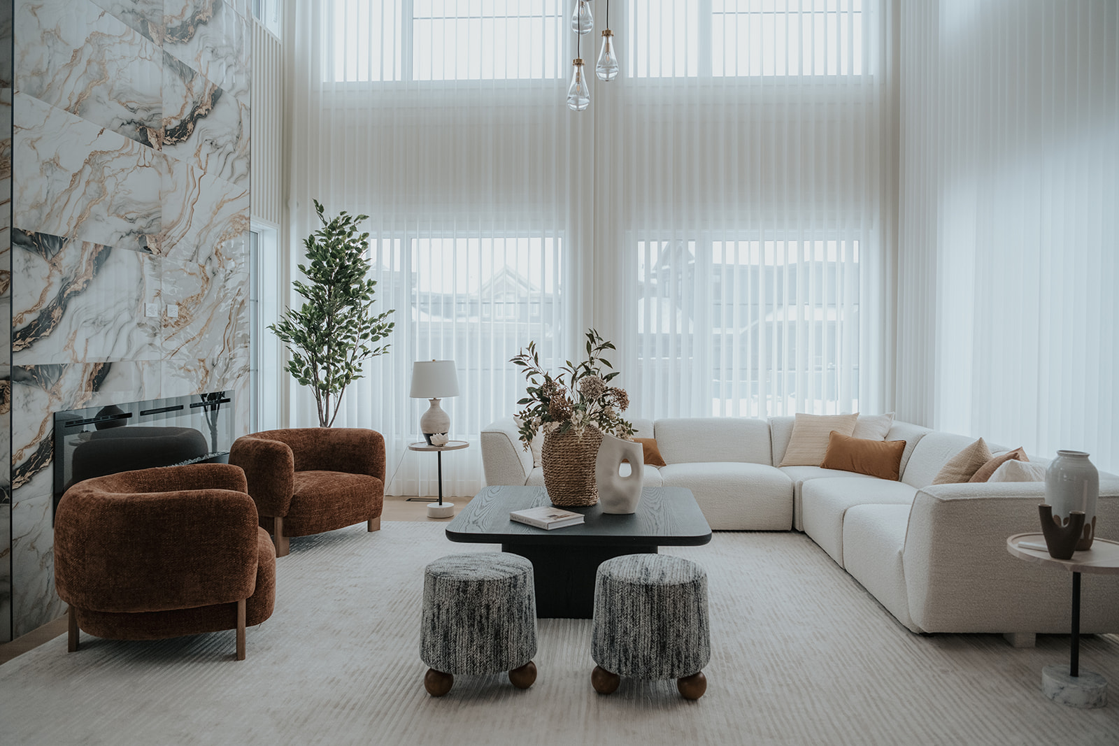 Novo vertical sheer curtains in a living room with a white sofa and marble fireplace