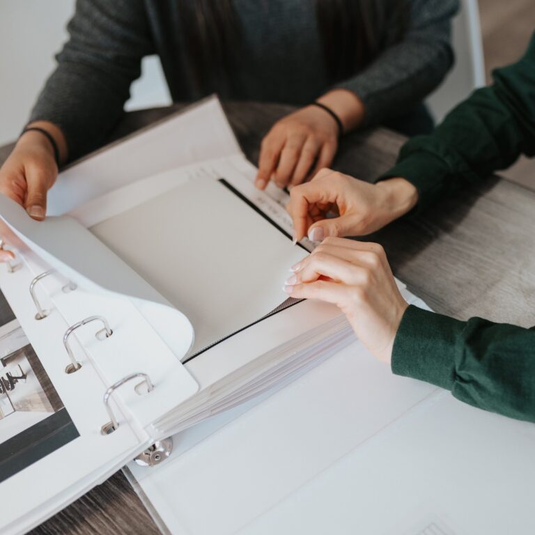 Hands comparing fabric samples in a Novo Blinds sample binder